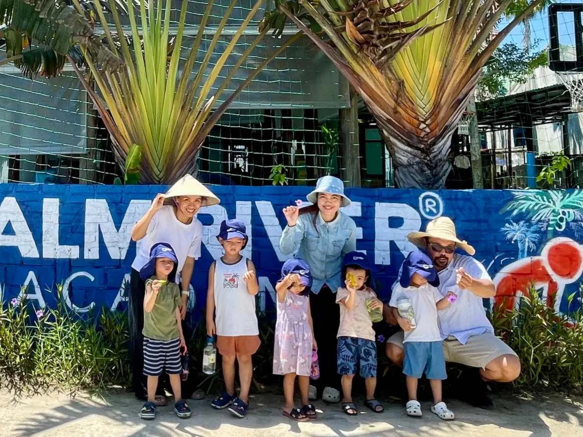 Students and staff at the painted campus wall at Palm River Academy
