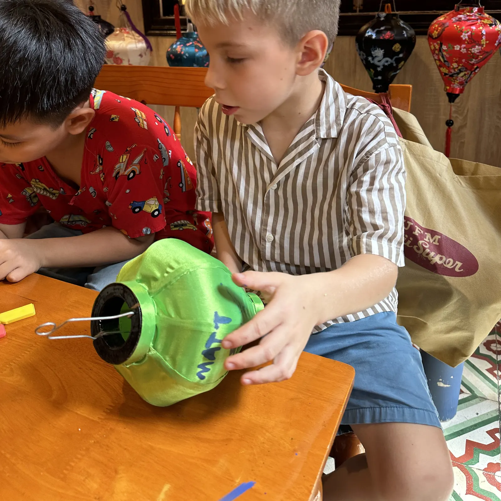 A student decorating a lantern in a Hội An lantern workshop