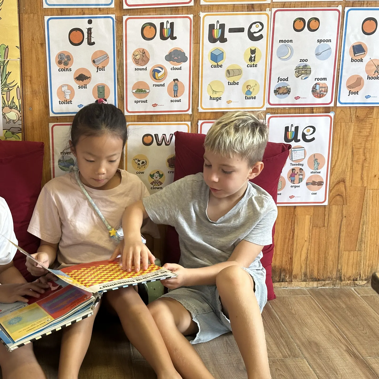 Children sharing a picture book in the reading corner