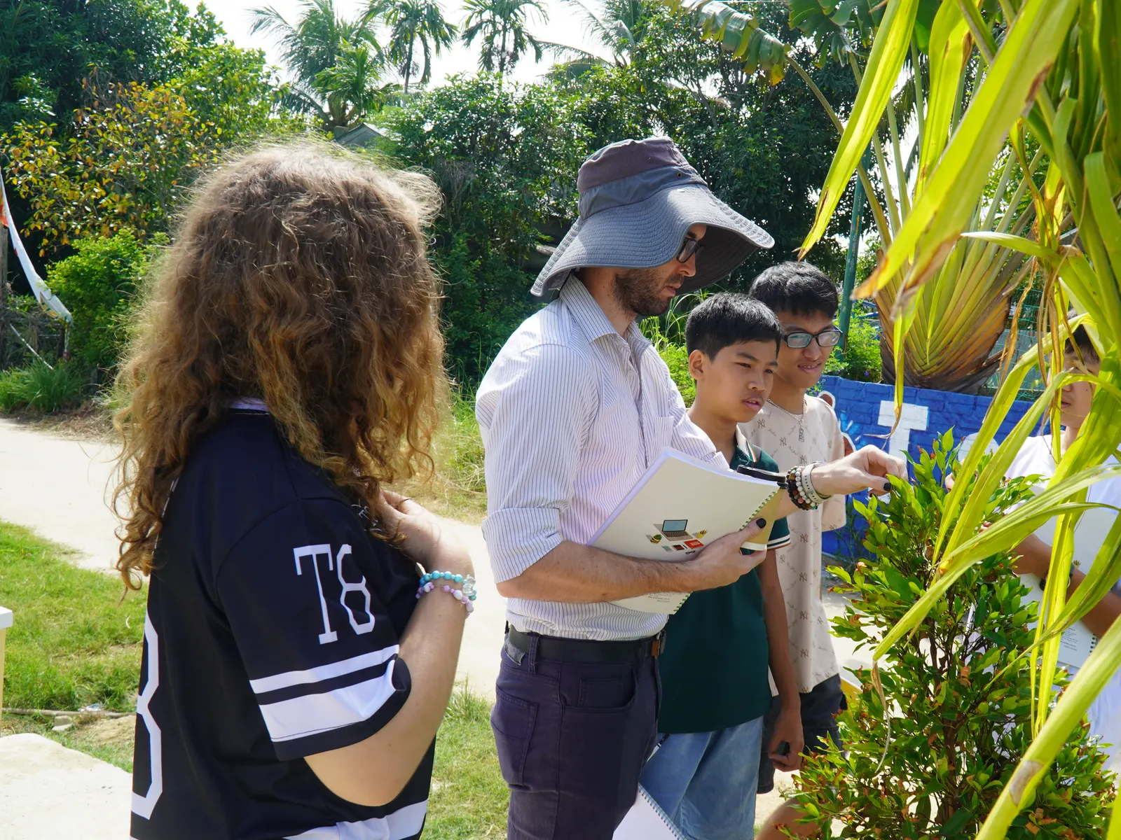 Mr. Bowen on a nature walk with Global Program students, noting down what they find