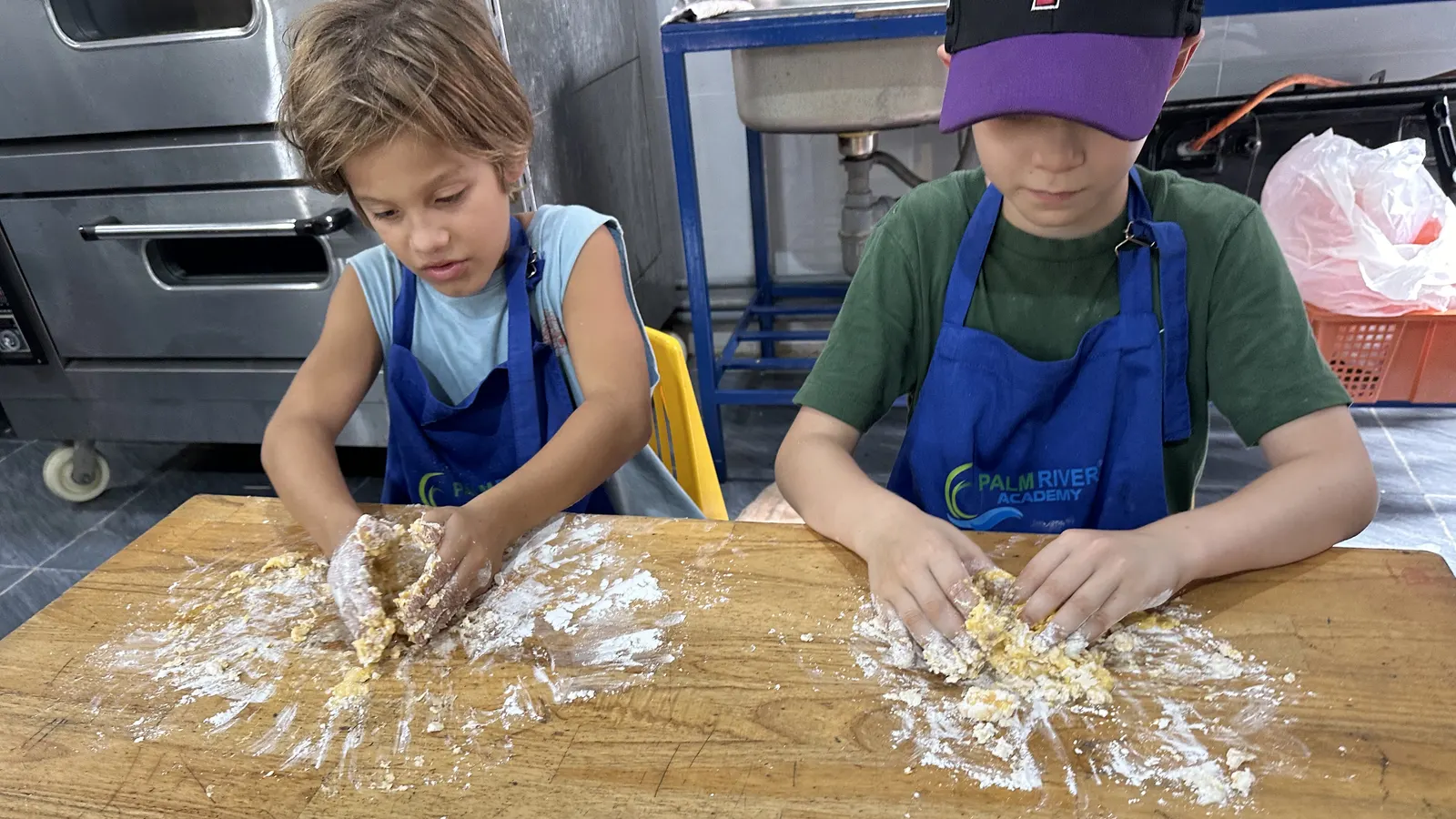 Students kneading bread dough in a cooking class at Palm River Academy in Hội An