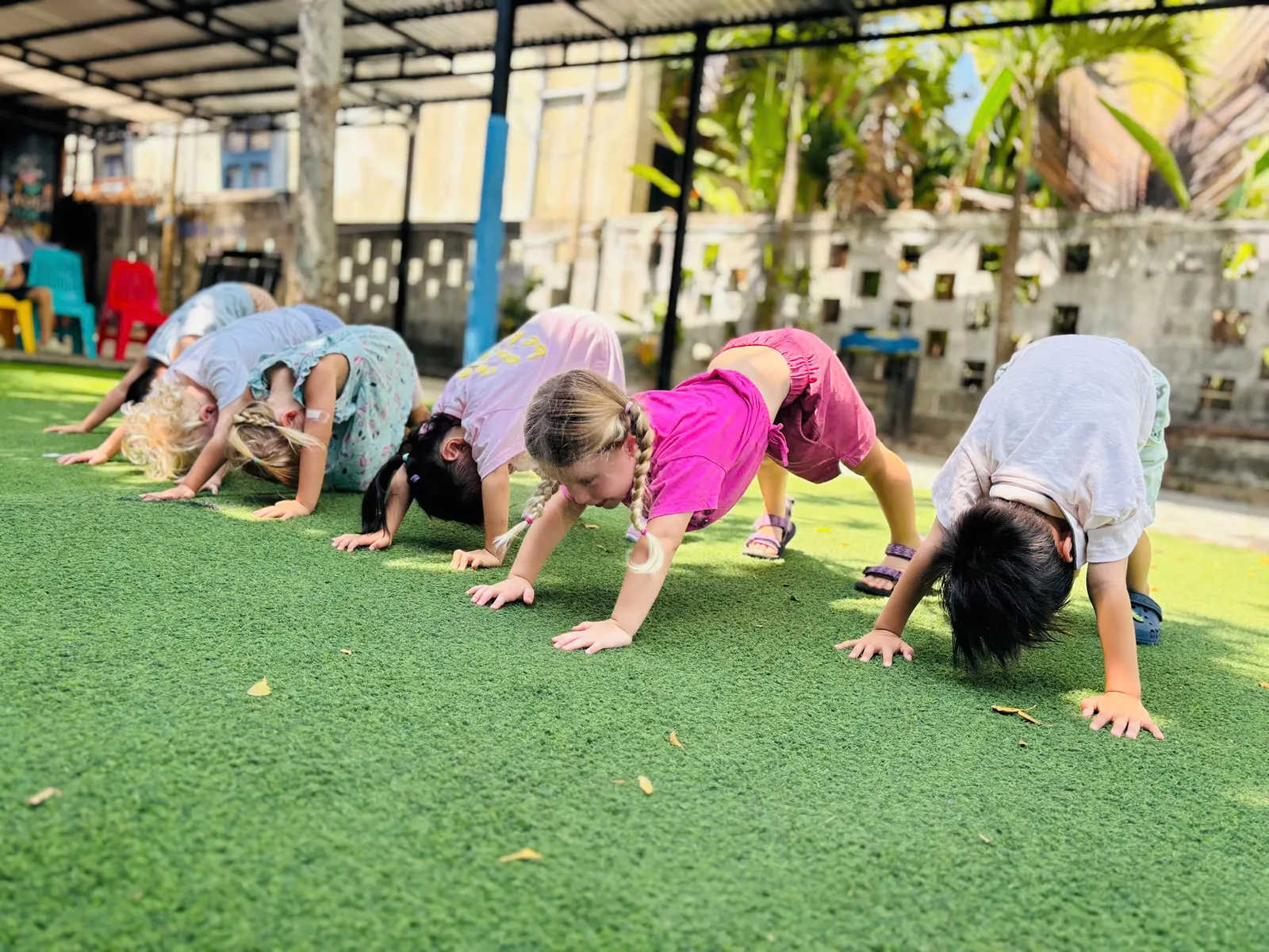 Early Years children doing yoga on the turf