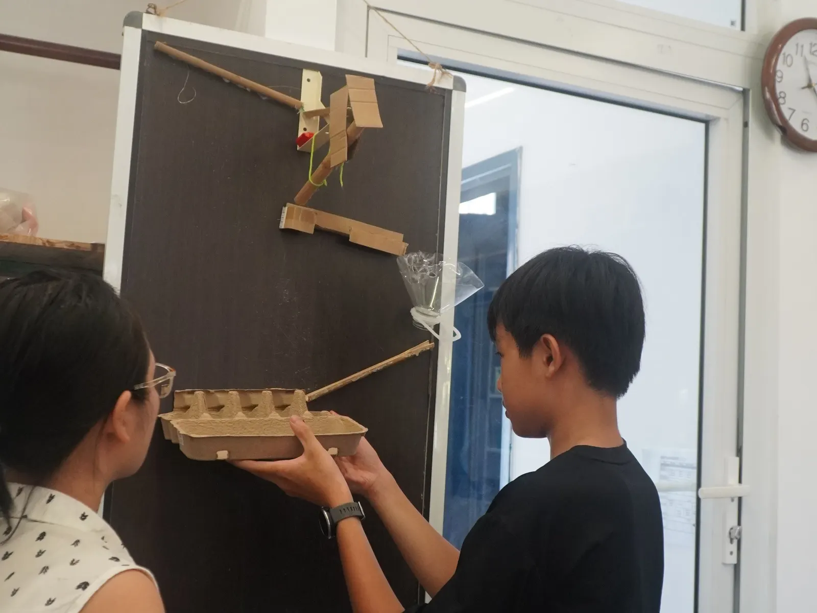 A student building a chain-reaction machine in the Maker Space