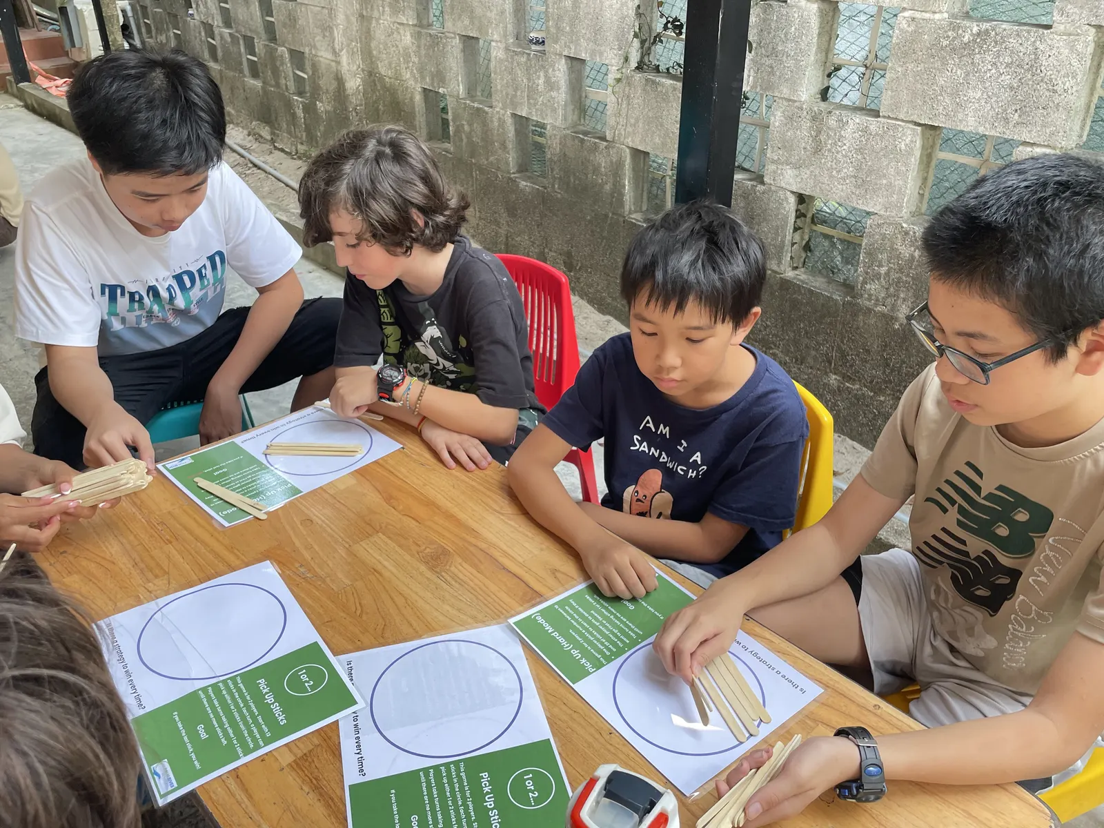 Students working out a strategy for a pick-up-sticks game at March Mathness
