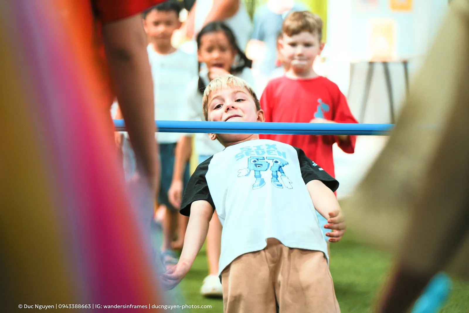 A child grinning while ducking under the limbo pole at the Mid-Autumn Festival