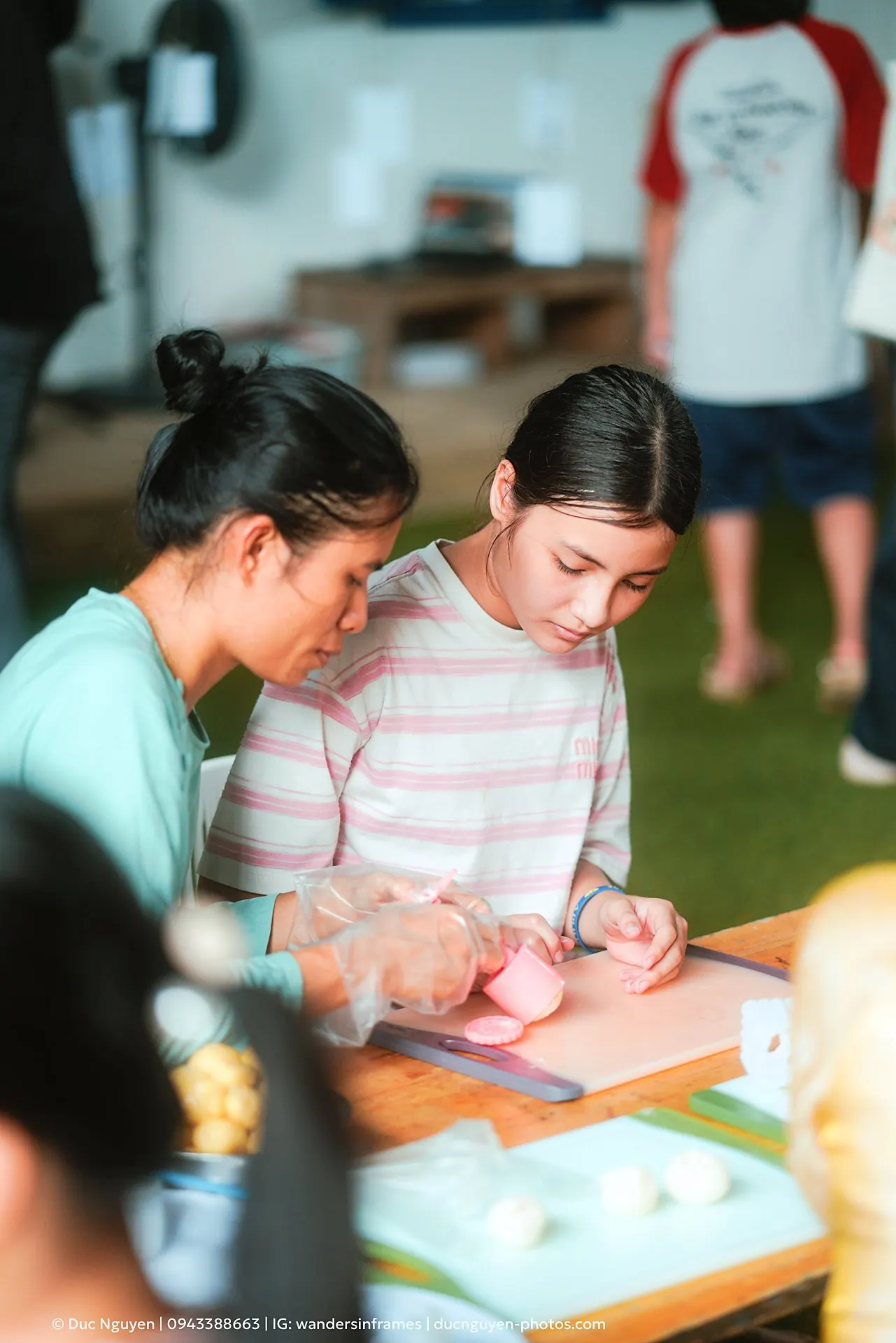 A student pressing a pink mooncake mould with Ms. Thắm V at the Mid-Autumn Festival