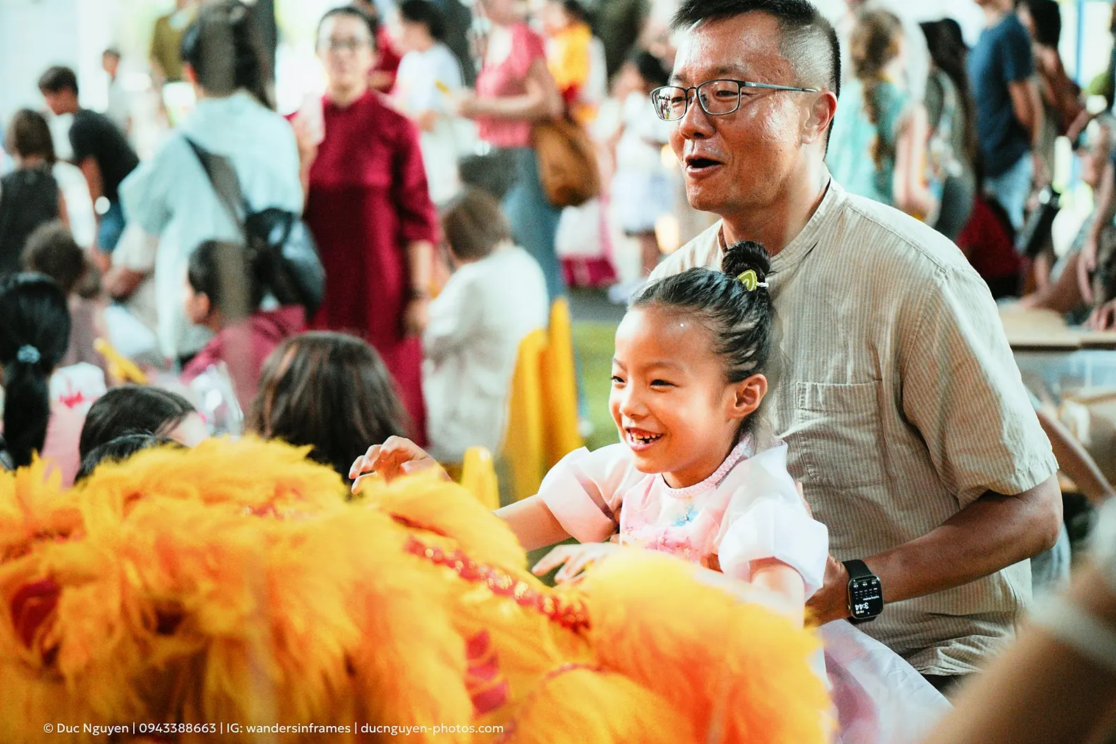 A child laughing and reaching for the yellow lion at the Mid-Autumn Festival
