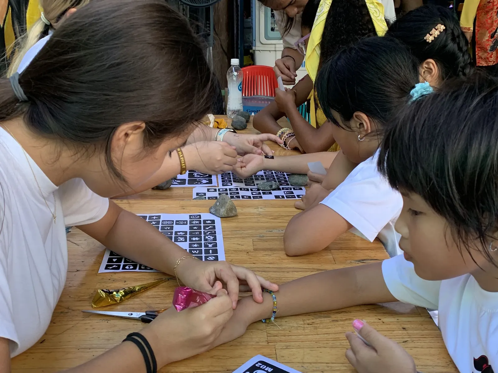 Students painting henna designs at the Mid-Autumn Festival fair