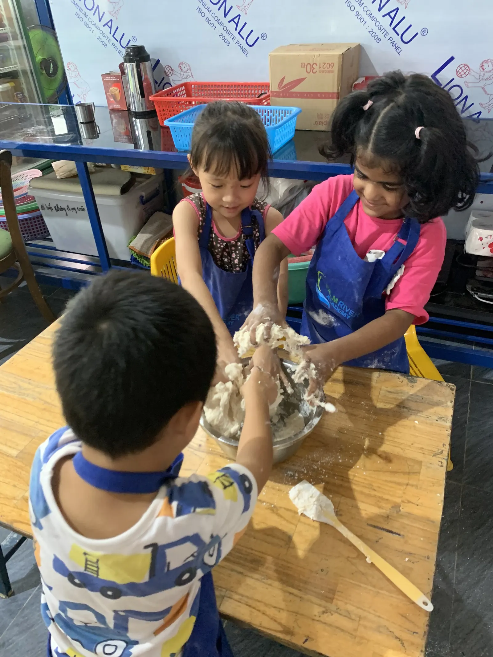 Primary students shaping dough in the kitchen at PRA