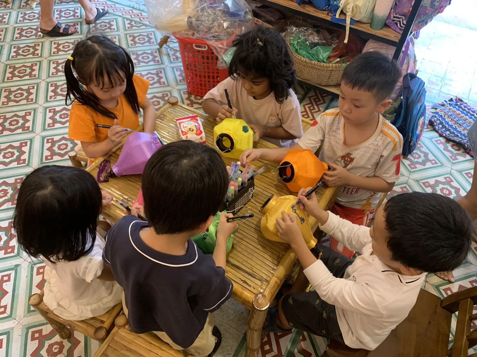 Primary students painting silk lanterns at a workshop in Hội An