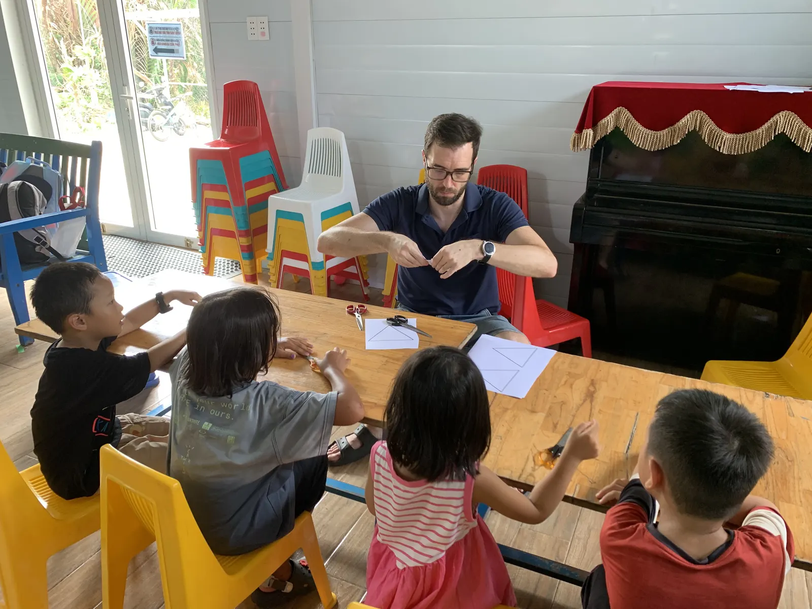 Mr. Bowen working through a cut-and-fold shapes activity with a Primary maths group