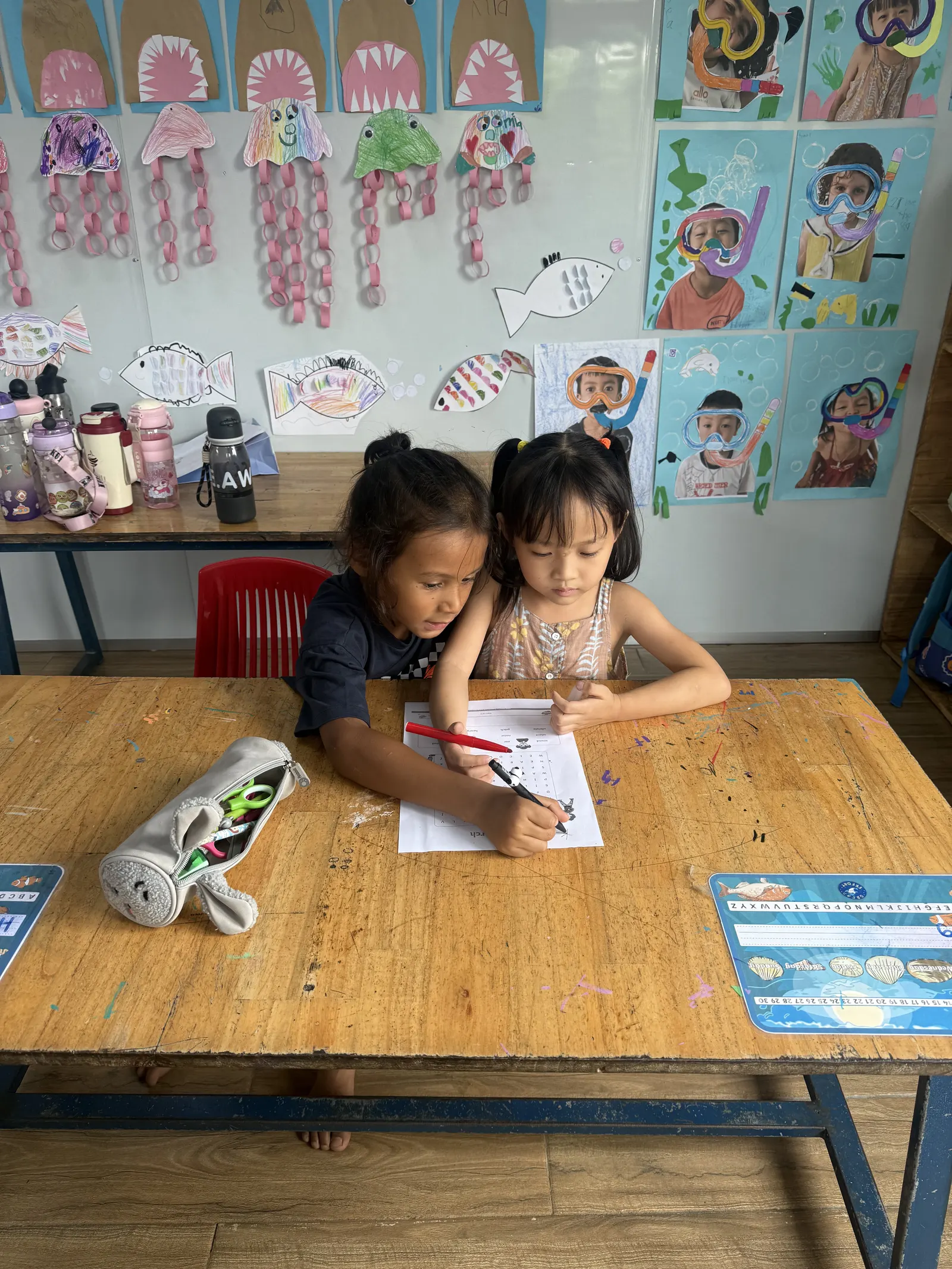 Two Primary students writing at their desk