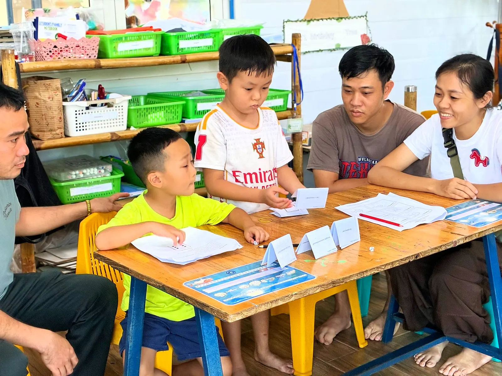 Một học viên Year 1 đọc thẻ câu hỏi Khoa học cho ba mẹ cùng bàn nghe