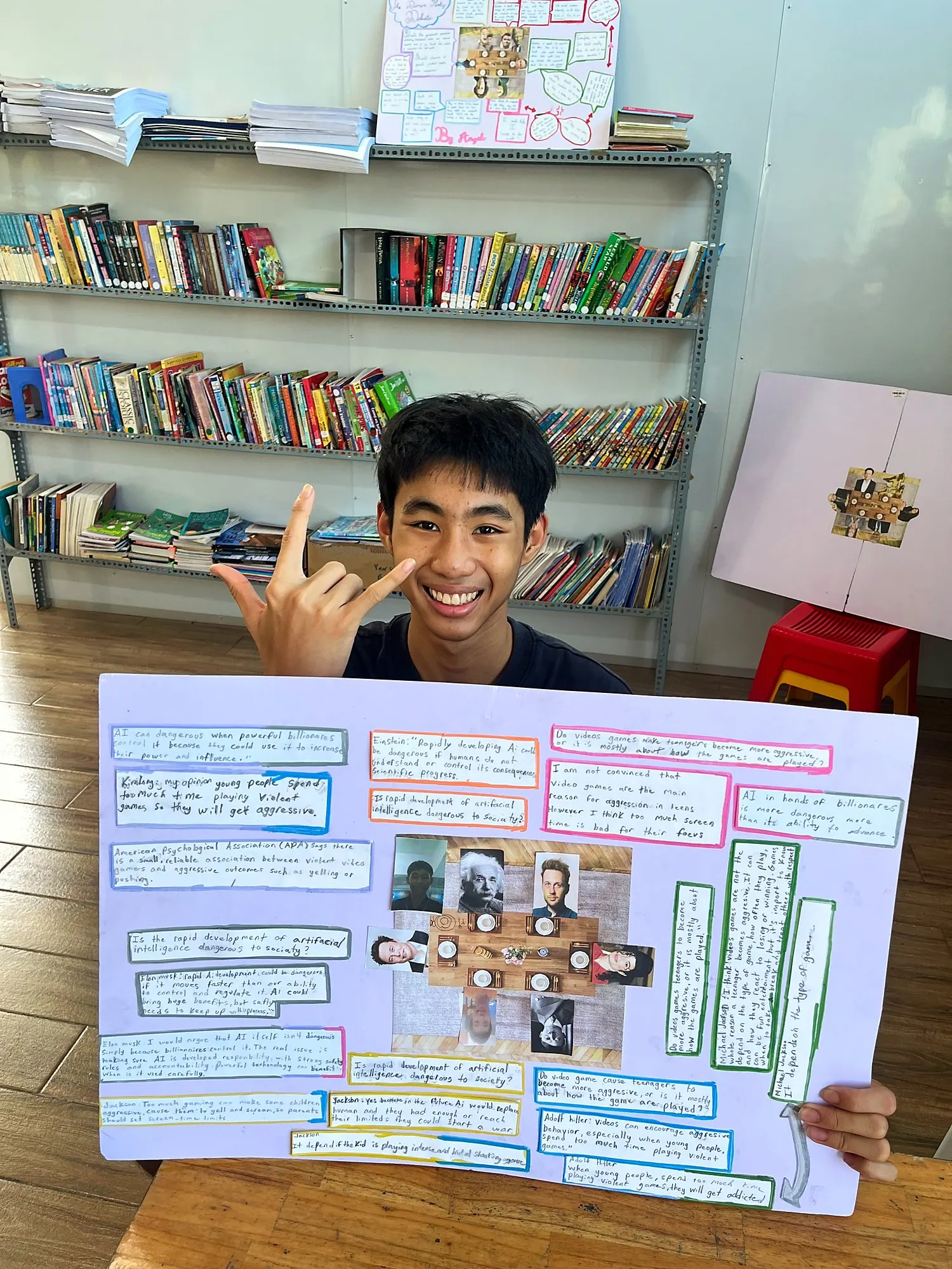Một học viên Upper Secondary cầm poster bữa tiệc tranh luận về trí tuệ nhân tạo và trò chơi điện tử