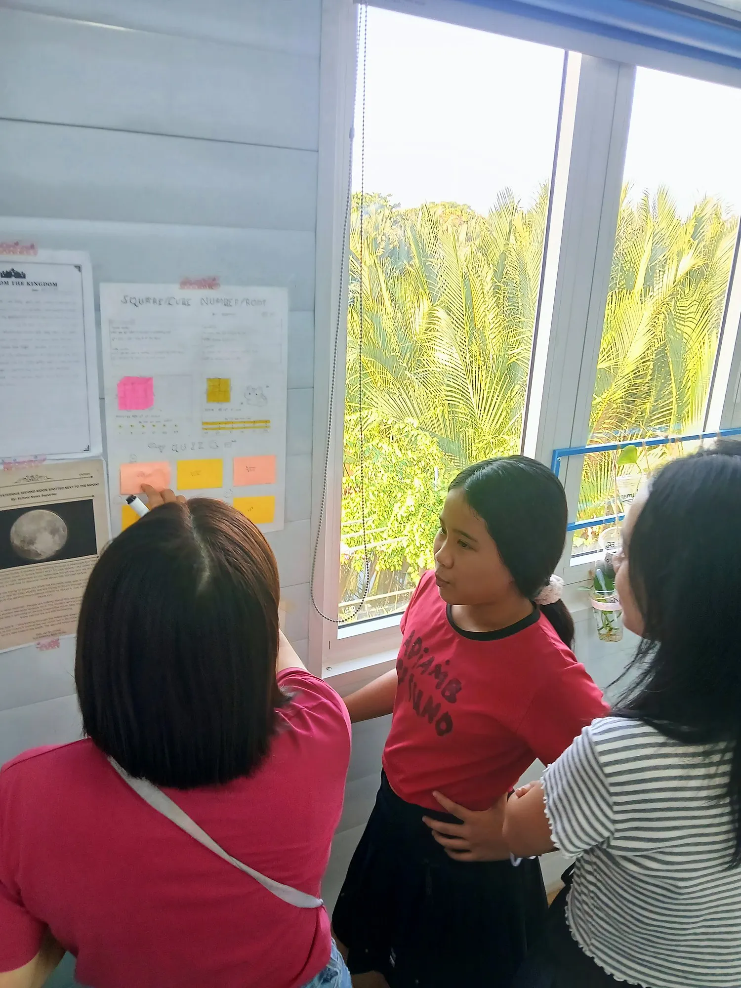 Một phụ huynh trả lời bài đố trên poster của học viên Lower Secondary về số chính phương và số lập phương