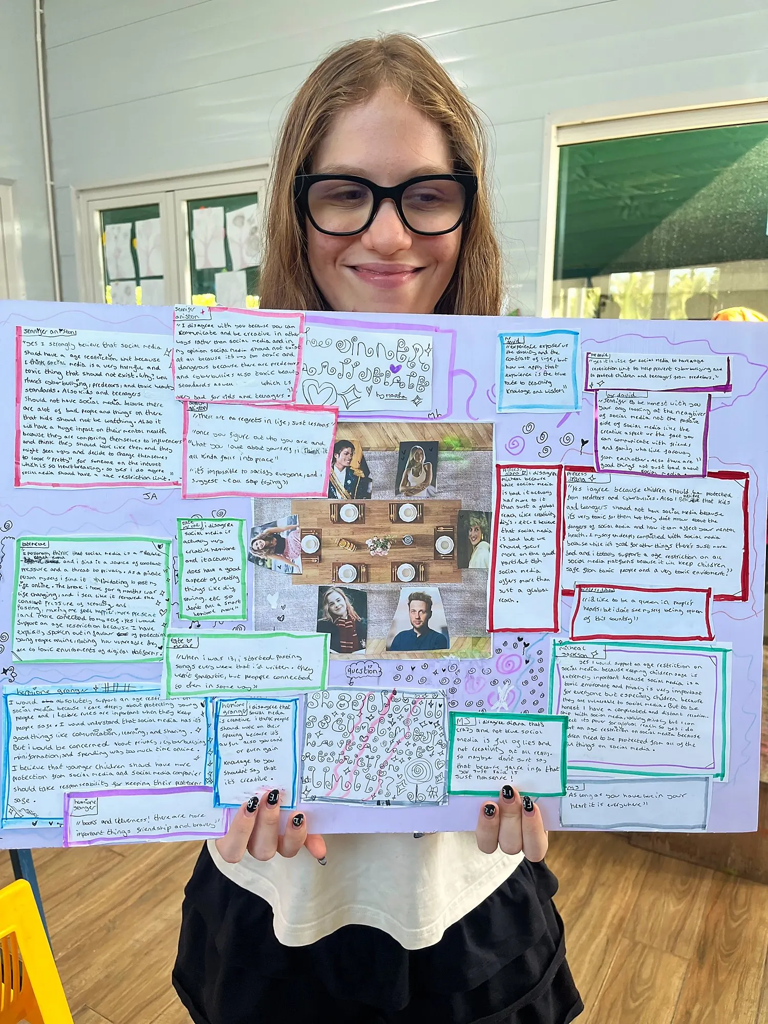 Một học viên Upper Secondary cầm poster bữa tiệc tranh luận về trẻ em và mạng xã hội