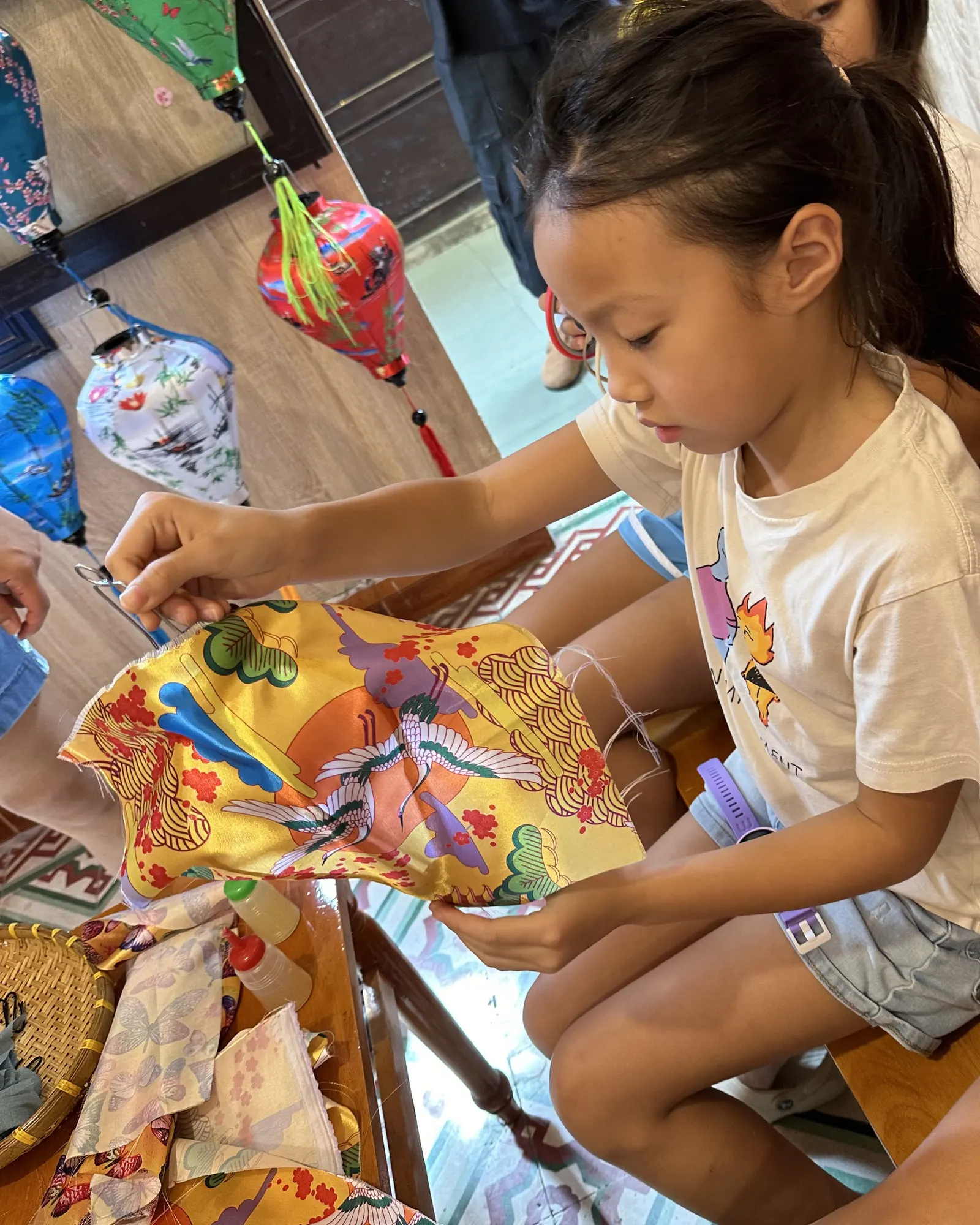 A student stitching a silk lantern in a Hội An lantern workshop