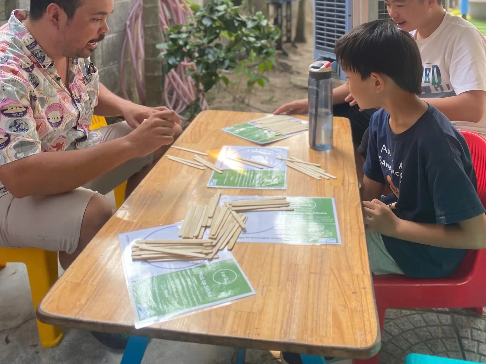 Mr. Seth playing a pick-up-sticks maths game with students at March Mathness