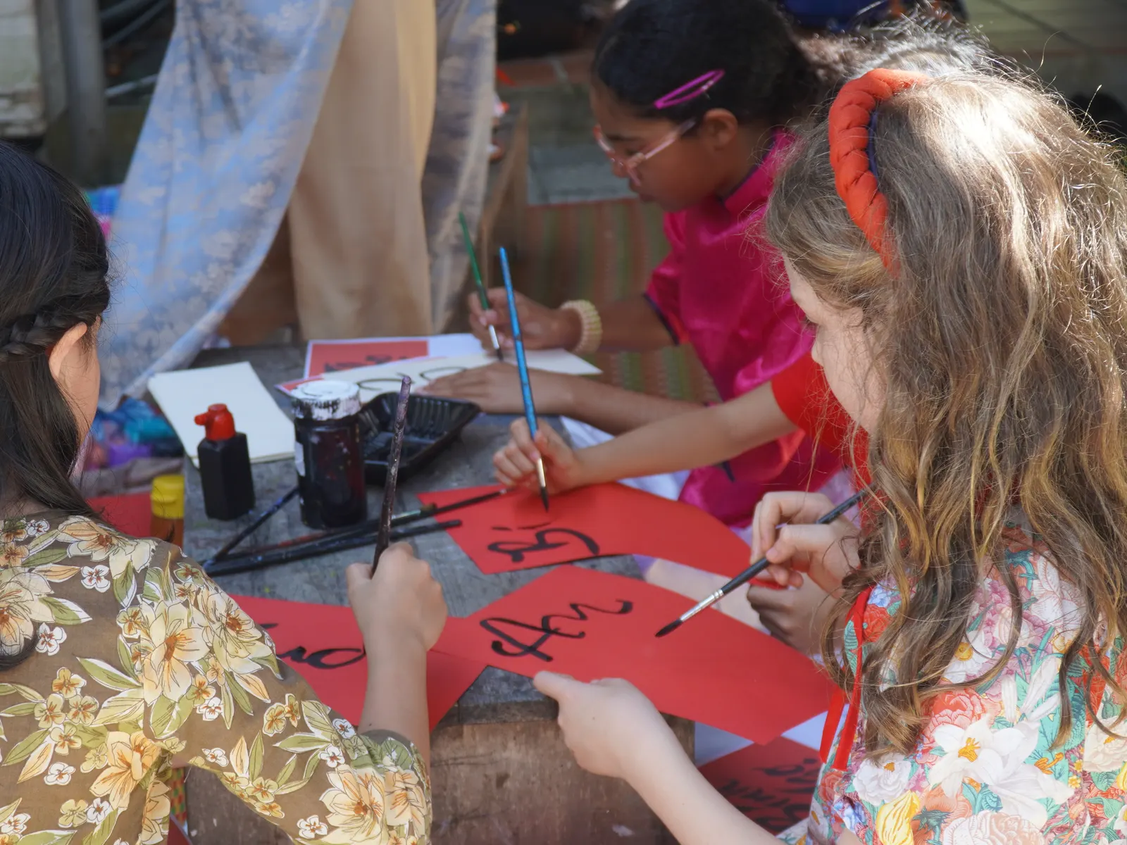 Students painting Vietnamese calligraphy for Tết