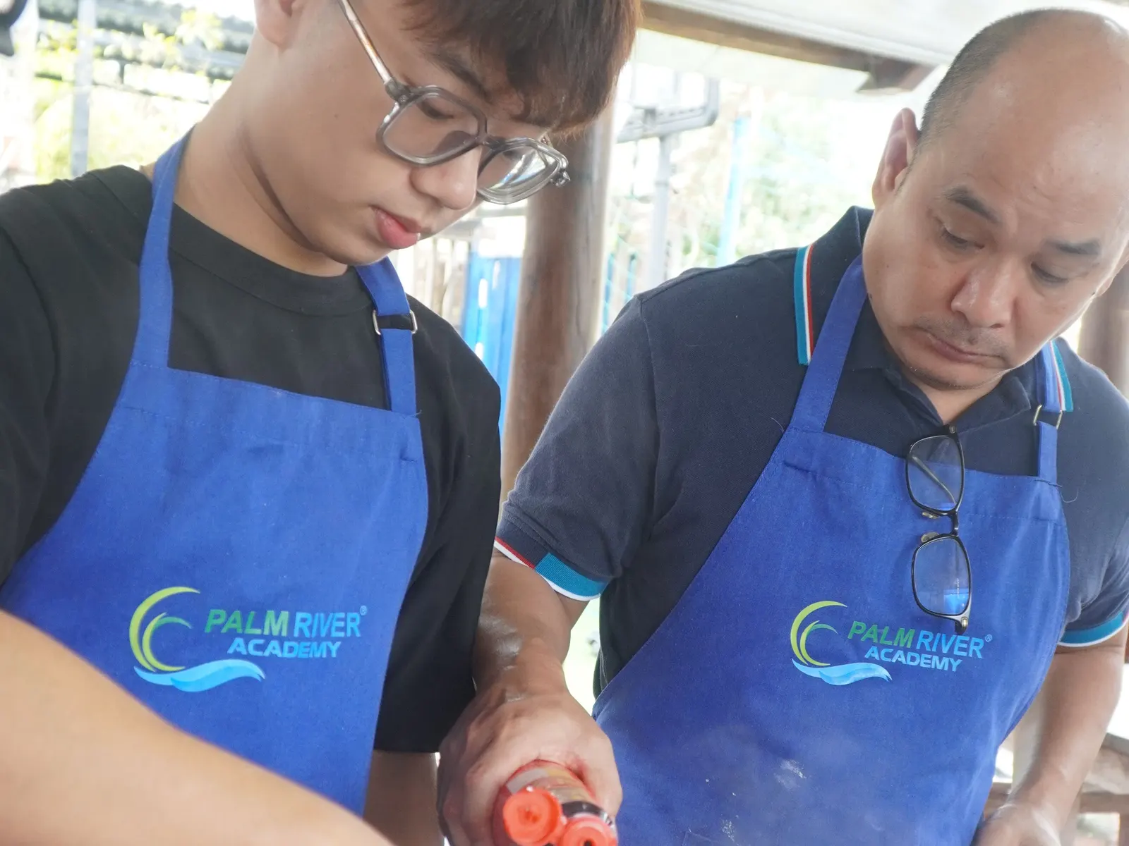 A student and their teacher cooking the Thanksgiving meal